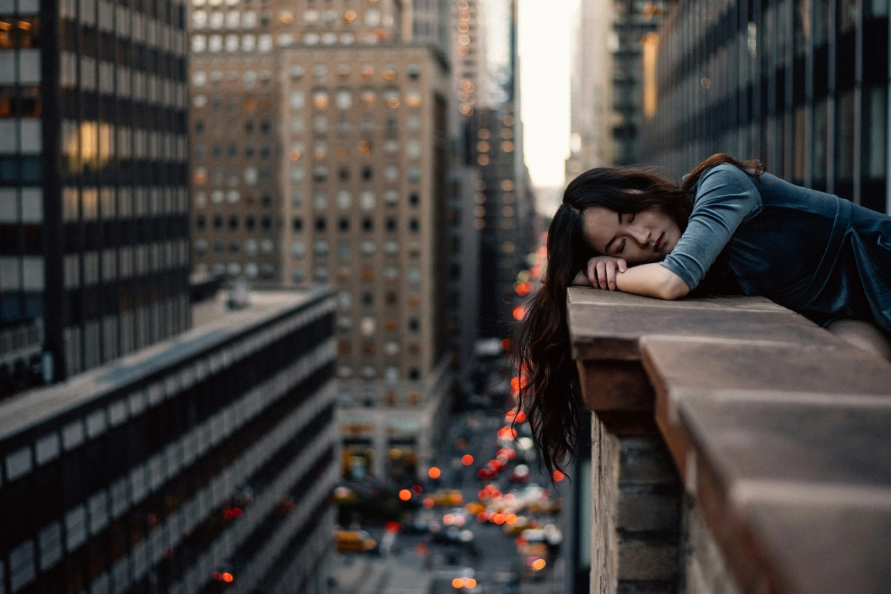 Woman experiencing burnout on a building ledge.